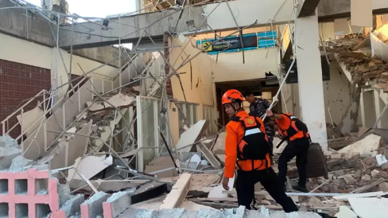 Personal de Protección Civil observan los daños sufridos por una edificación.